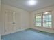 Well-lit bedroom with double closet doors and a large window overlooking the front yard at 4005 King Charles Rd, Durham, NC 27707