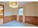 Dining room with a vintage chandelier, wood trim, and a window at 4005 King Charles Rd, Durham, NC 27707