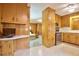 Open kitchen area featuring wood cabinets, tile flooring, and a breakfast bar overlooking the adjacent living area at 4005 King Charles Rd, Durham, NC 27707