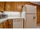 Charming kitchen featuring wooden cabinets, a white refrigerator, and a built-in dishwasher for modern convenience at 4005 King Charles Rd, Durham, NC 27707