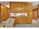 Cozy den area featuring wood cabinets and breakfast bar, offering a convenient transition to the kitchen at 4005 King Charles Rd, Durham, NC 27707