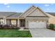 Charming brick home featuring a two-car garage and a cozy front porch seating area at 4020 Kinsley Trce, Burlington, NC 27215