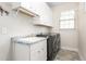Well-lit laundry room with modern washer and dryer, sink, cabinets and granite countertops at 4020 Kinsley Trce, Burlington, NC 27215