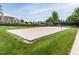 A sand volleyball court with net, surrounded by green grass, perfect for outdoor games and community activities at 4020 Kinsley Trce, Burlington, NC 27215