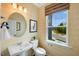 Modern half bathroom featuring designer wallpaper, decorative mirror, and stylish fixtures at 410 Rowe Way, Knightdale, NC 27545