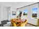 Bright dining room with a round table, yellow chairs, and large windows with sheer curtains at 410 Rowe Way, Knightdale, NC 27545
