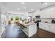 Open kitchen with white cabinets, granite countertops, stainless steel appliances, and bar seating at 410 Rowe Way, Knightdale, NC 27545