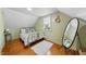 Bright bedroom features hardwood floors, a cozy rug, and a mirror, creating a serene and inviting atmosphere at 417 S Fourth St, Mebane, NC 27302