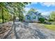 Well-maintained home featuring a spacious gravel driveway, lush greenery, a rear house, and an outbuilding at 417 S Fourth St, Mebane, NC 27302