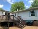 View of back deck with wood stairs leading down to the yard with grill and lots of privacy at 4172 Copeland Ter, Graham, NC 27253