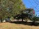 A large backyard with a wooden bench and mature trees offer a relaxing setting at 4172 Copeland Ter, Graham, NC 27253