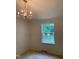 Living room featuring large windows, neutral carpet, and classic lighting fixture at 4172 Copeland Ter, Graham, NC 27253