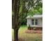 Residential side yard featuring mature tree, landscaping and home exterior at 4172 Copeland Ter, Graham, NC 27253