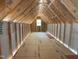 Unfinished attic features wood framing and a single window allowing natural light to enter the space at 485 Chapel Ridge Dr, Pittsboro, NC 27312
