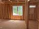 Unfinished bedroom features wood framing, a single window, and light entering the room at 485 Chapel Ridge Dr, Pittsboro, NC 27312