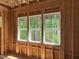 Unfinished bedroom showcasing three windows offering natural light and a view of the surrounding trees at 485 Chapel Ridge Dr, Pittsboro, NC 27312