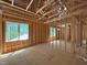 Unfinished bedroom showcasing wood framing and windows offering views of the neighborhood trees at 485 Chapel Ridge Dr, Pittsboro, NC 27312