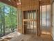 Unfinished living room with a fireplace showing the wood framing and view of the backyard trees at 485 Chapel Ridge Dr, Pittsboro, NC 27312