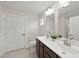 Bathroom with dual sinks, a large mirror, and white toilet, along with a door to the shower at 55 Boots Ridge Way, Franklinton, NC 27525