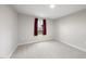 Simple bedroom featuring a window with dark red curtains and neutral carpet at 55 Boots Ridge Way, Franklinton, NC 27525