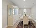 Bright dining area with white furniture, a display cabinet, and natural light from a nearby window at 55 Boots Ridge Way, Franklinton, NC 27525