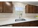 Close up of kitchen sink with stainless steel faucet, white countertop, and ample natural light from window at 55 Boots Ridge Way, Franklinton, NC 27525