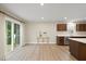 Open-concept living space adjacent to a modern kitchen, featuring wood floors and large sliding glass door at 55 Boots Ridge Way, Franklinton, NC 27525