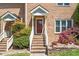 Close-up of the front door and entryway of a brick townhome, showing the steps and landscaping at 5500 Fortunes Ridge Dr # 82B, Durham, NC 27713