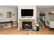 Warm living area with fireplace and mounted TV; hardwood floors extend into dining area at 5500 Fortunes Ridge Dr # 82B, Durham, NC 27713