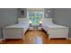 This bedroom features two twin beds, hardwood floors, and a window overlooking the backyard at 5600 Treestand Ct, Garner, NC 27529