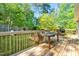 Wooden back deck with a picnic table, grill, and a fenced yard at 5860 Andover Dr, Graham, NC 27253
