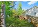 Green backyard featuring a wood deck with outdoor furniture and an adjacent home at 5860 Andover Dr, Graham, NC 27253