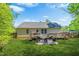 Backyard with green grass, a fenced perimeter, a deck, and an adjacent home at 5860 Andover Dr, Graham, NC 27253