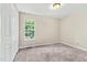 Bedroom featuring neutral walls, carpet and a window overlooking the side yard at 5860 Andover Dr, Graham, NC 27253