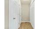 Hallway with multiple white doors and light hardwood flooring at 5860 Andover Dr, Graham, NC 27253