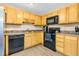 Bright kitchen with stainless steel sink, black appliances and wood cabinets at 5860 Andover Dr, Graham, NC 27253