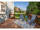A wooden deck furnished with a pair of blue chairs and a blue table with flowers overlooking the backyard at 612 Spring Meadow Dr, Durham, NC 27713