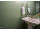 Stylish powder room features olive green walls, modern fixtures, and a pedestal sink at 612 Spring Meadow Dr, Durham, NC 27713
