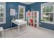 Bedroom with blue walls, a white desk and shelving with three large windows at 612 Spring Meadow Dr, Durham, NC 27713