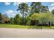 Street view of a landscaped front lawn, mature trees, and a two-story home at 612 Spring Meadow Dr, Durham, NC 27713