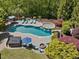 Aerial view of a pool and spa, surrounded by lush landscaping and multiple seating areas at 6824 Wood Forest Dr, Cary, NC 27519