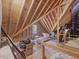 Spacious unfinished attic with exposed wood beams and a small window at 6824 Wood Forest Dr, Cary, NC 27519