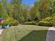 Expansive backyard featuring a well-manicured lawn, mature trees, and a stone paver border around the edge of the yard at 6824 Wood Forest Dr, Cary, NC 27519