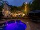 Illuminated pool and patio with landscape lighting, with an elevated deck and home exterior at twilight at 6824 Wood Forest Dr, Cary, NC 27519