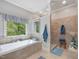 Spacious bathroom featuring a soaking tub, walk-in shower, and natural light at 6824 Wood Forest Dr, Cary, NC 27519