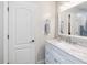 Bathroom featuring a marble countertop, white cabinets, and a large framed mirror with vanity lighting at 6824 Wood Forest Dr, Cary, NC 27519