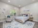 Bright bedroom with a wood bed frame, patterned rug, and a window letting in natural light at 6824 Wood Forest Dr, Cary, NC 27519