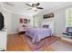 Cozy bedroom featuring hardwood floors, a white-framed bed, and a colorful rug at 6824 Wood Forest Dr, Cary, NC 27519