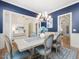 Elegant dining room featuring blue accent wall, stylish chandelier, and seating for six at 6824 Wood Forest Dr, Cary, NC 27519