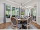 Bright dining area features large windows, a stylish chandelier, and seating for six at 6824 Wood Forest Dr, Cary, NC 27519